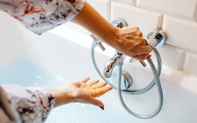 Woman using a bath faucet